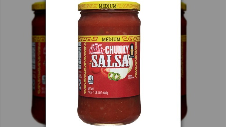a jar of Casa Mamita Medium Salsa, a red, tomato-based salsa, against a white background.