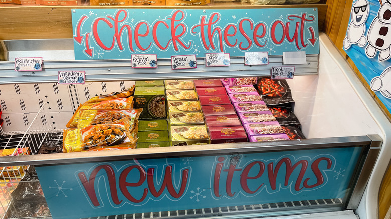 A section of the Trader Joe's frozen aisle with handwritten signs reading 