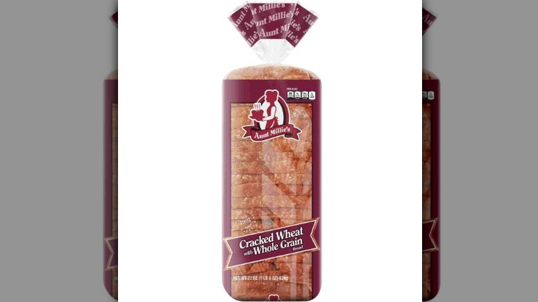 a loaf of Aunt Millie's Cracked Wheat With Whole Grain bread in its packaging.