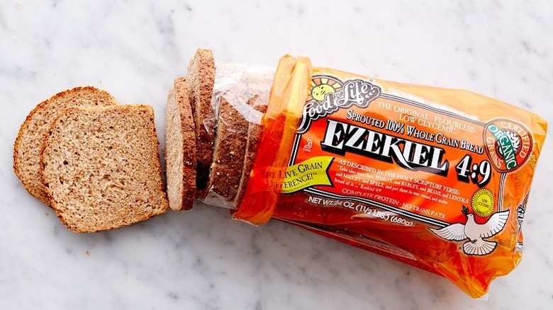 a loaf of Exekiel 4:9 Sprouted 100% Whole Grain Bread on a white counter.