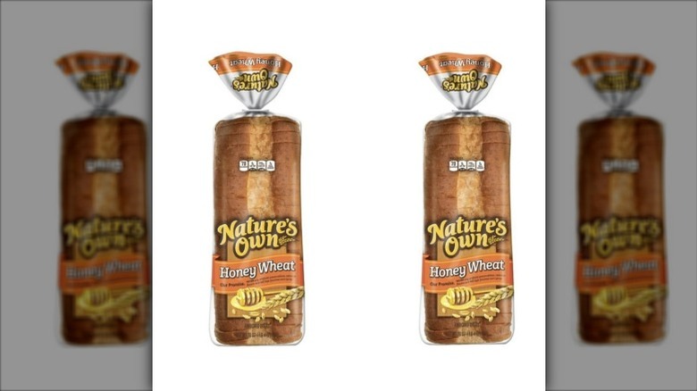 two loaves of Nature's Own Honey Wheat bread in their packaging against a white background.