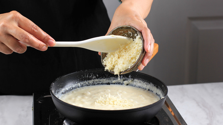 Person making cheese sauce