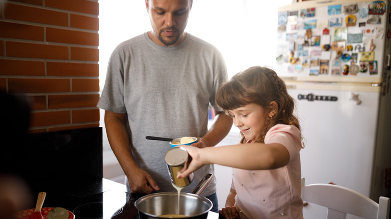 man and young girl cooking