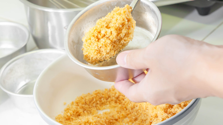 Person scooping crushed crackers