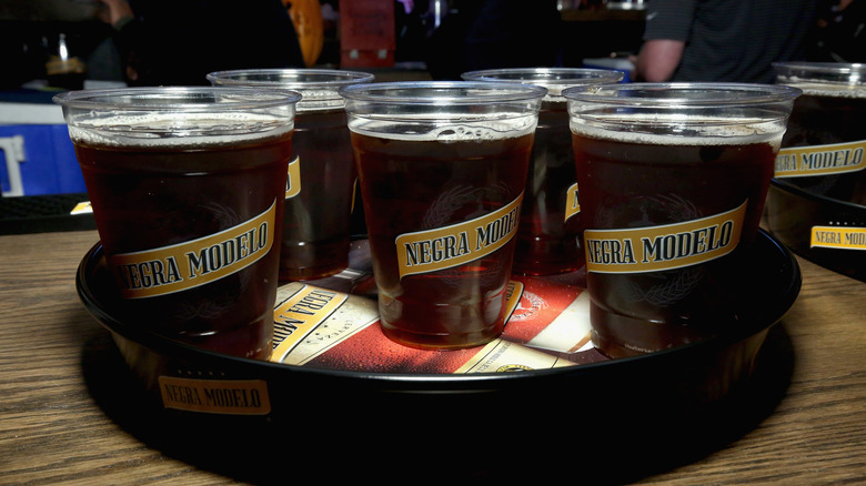 A tray of plastic cups of Negra Modelo beer