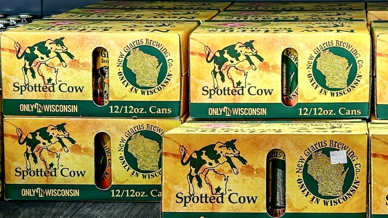 Packs of New Glarus Spotted Cow beer in a retail fridge