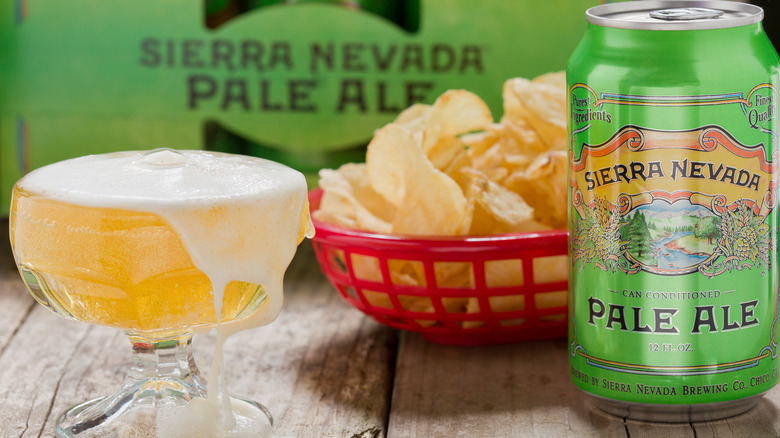 A Sierra Nevada Pale Ale can and goblet next to chips