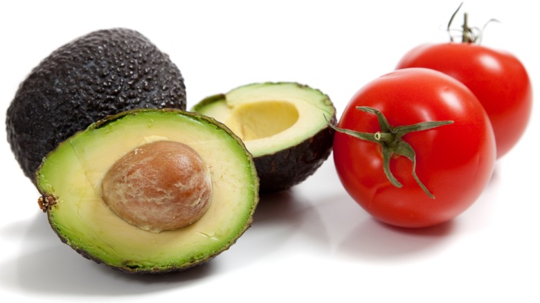 Avocados and tomatoes isolated on a white background