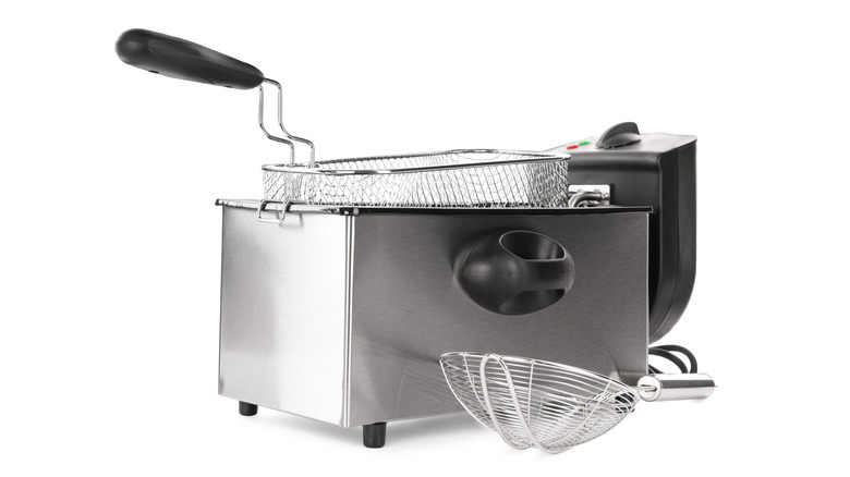Countertop deep fryer and baskets isolated on a white background