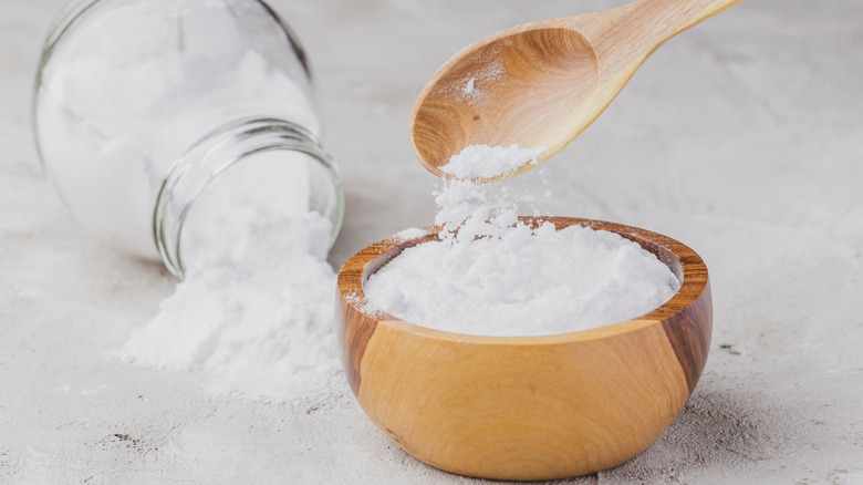 Baking soda in a jar and in a wooden bowl with a spoon