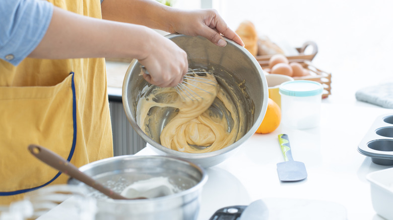 A woman making cake batter in a bowl