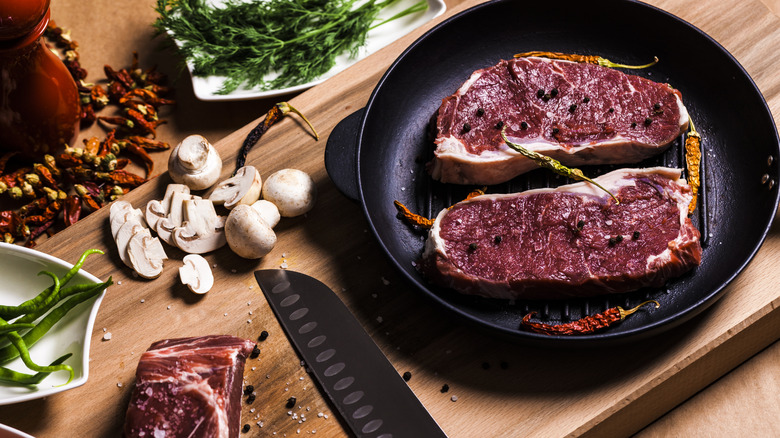 Raw steaks in a cast iron pan