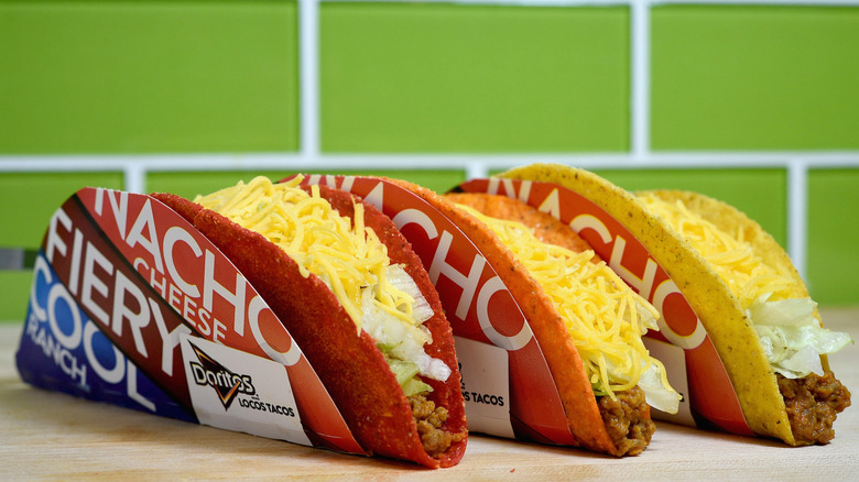 three Taco Bell Doritos Locos Tacos lined up still in their paper shell