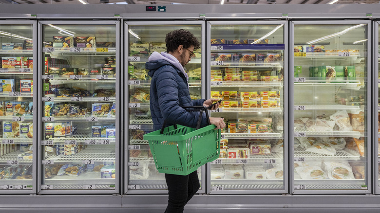 man shopping frozen food aisle