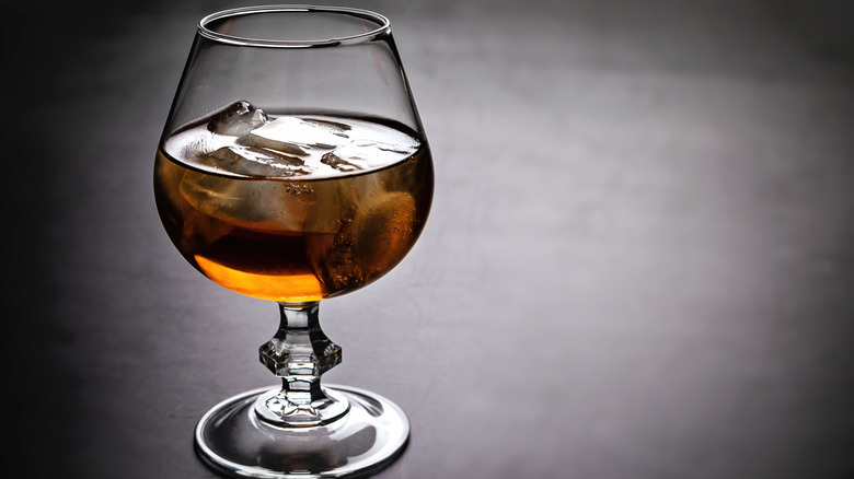 A glass of whiskey, with a few ice cubes