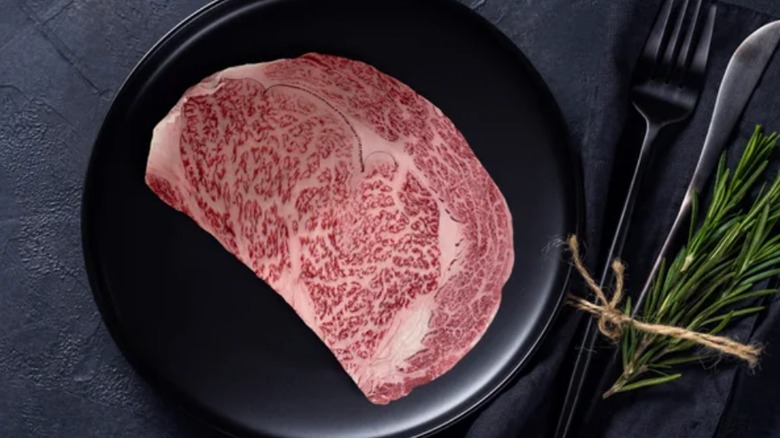 Wagyu ribeye steak on a black plate