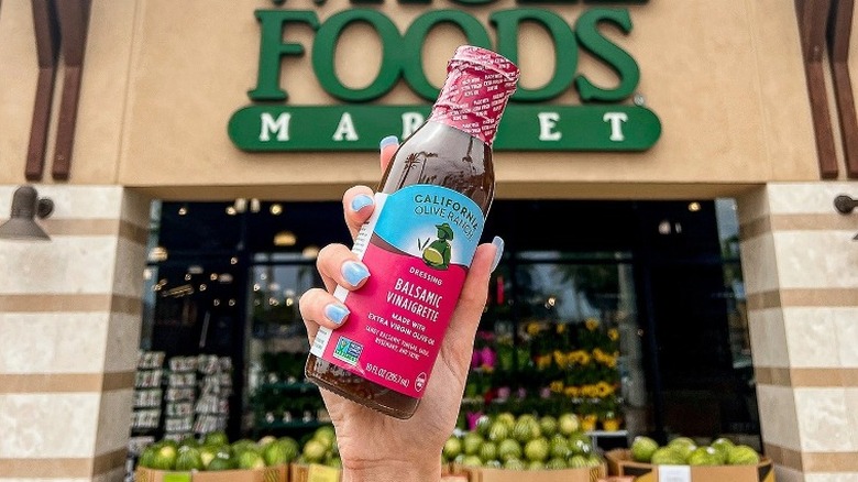 Hand holding dressing outside Whole Foods