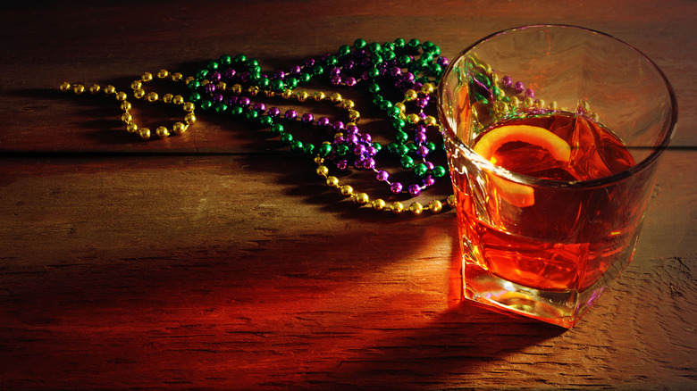 a Sazerac and beads on the bar