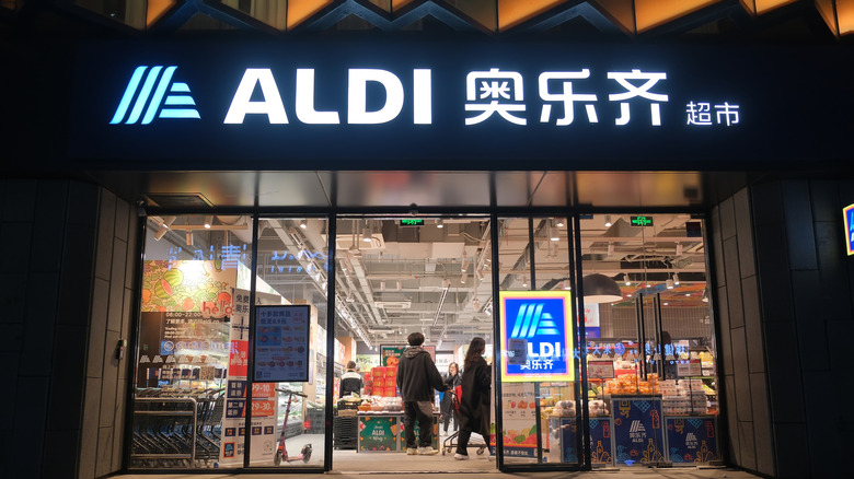 front view of an Aldi in China with the automatic doors open and customers at the threshold.