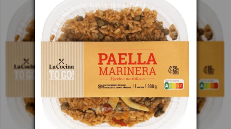 a plastic tub of paella marinera against a white background.