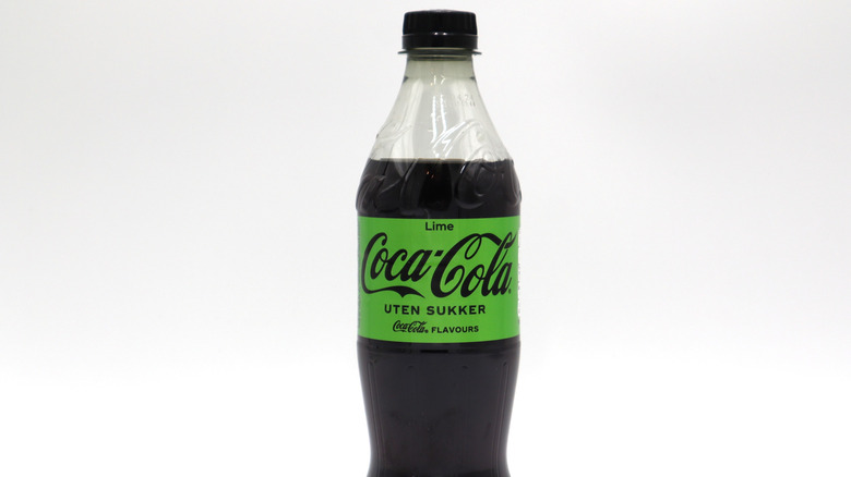 A bottle of Coca-Cola Lime with a green label against a white background.