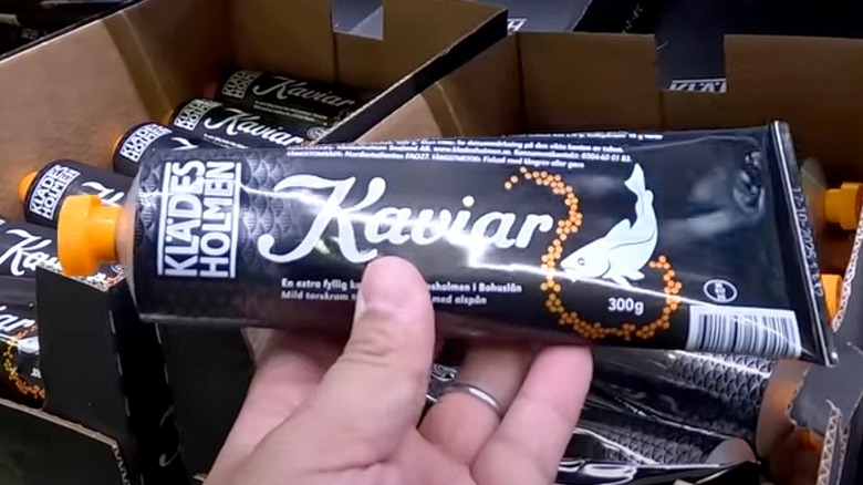 Hand holding a tube of Klädes Holmen Cod Caviar
