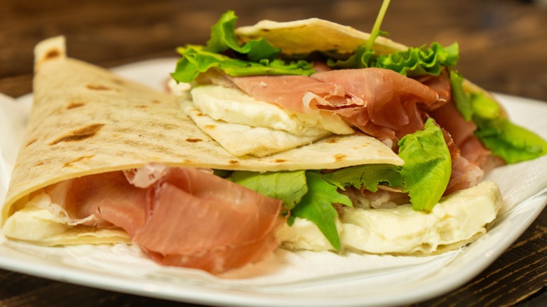 Piadina sandwiches filled with prosciutto, cheese, and lettuce