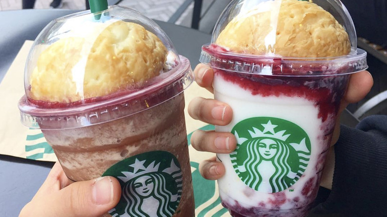 Hands holding Starbucks drinks