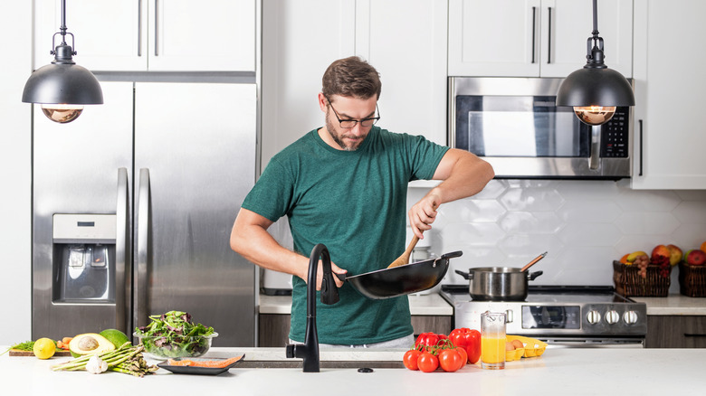 Man using wooden spoon in a pan