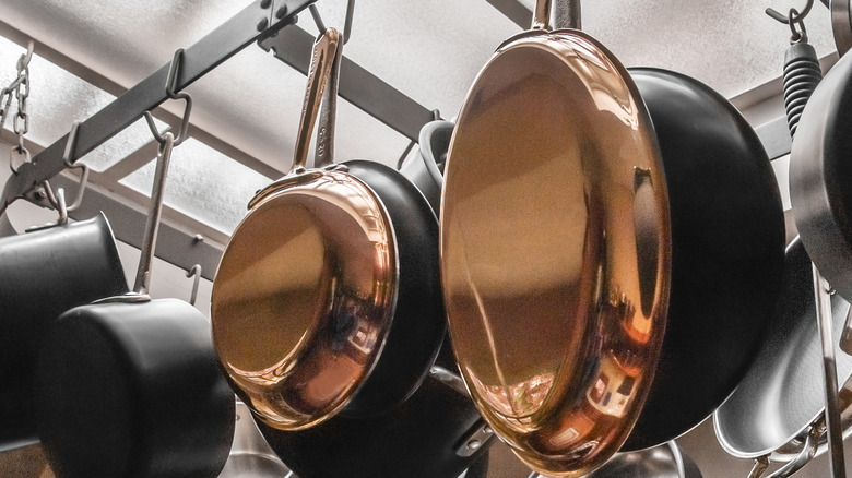 Copper and iron pans hanging in kitchen