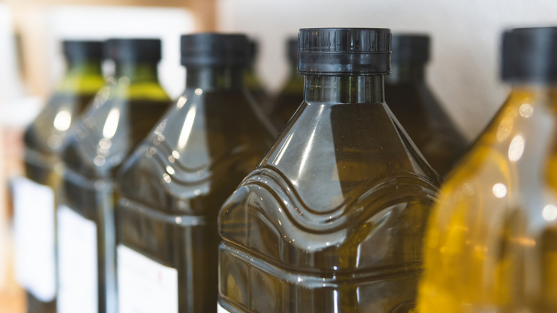 Plastic bottles of olive oil on shelf