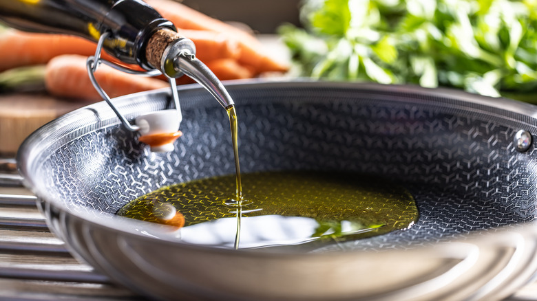 Olive oil being poured into pan