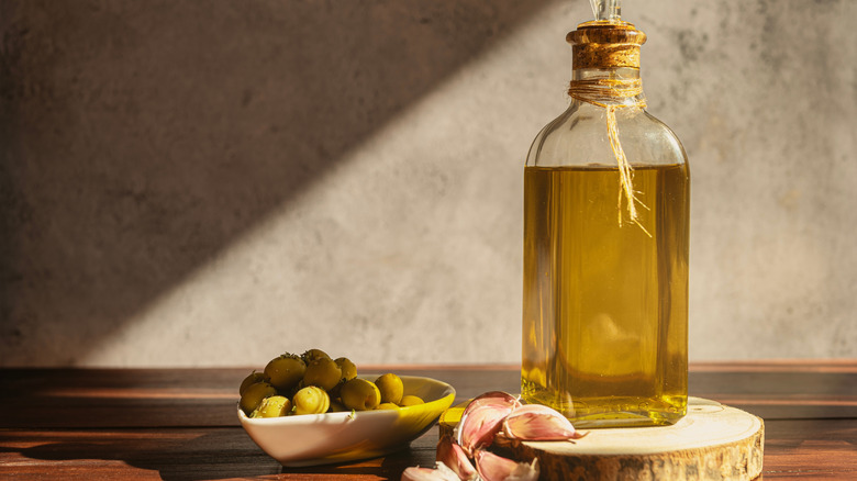 Olive oil bottle with olives and garlic