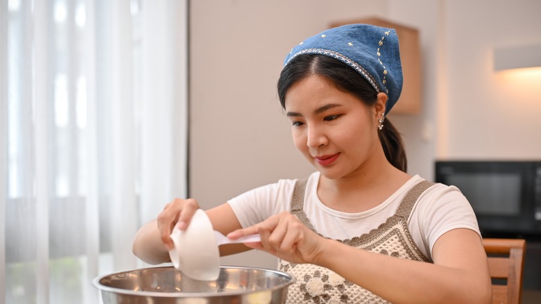 Person putting sugar in bowl