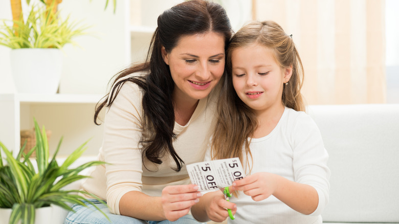 mother and daughter clipping coupons