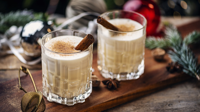 Two glasses of Eggnog on a wooden board