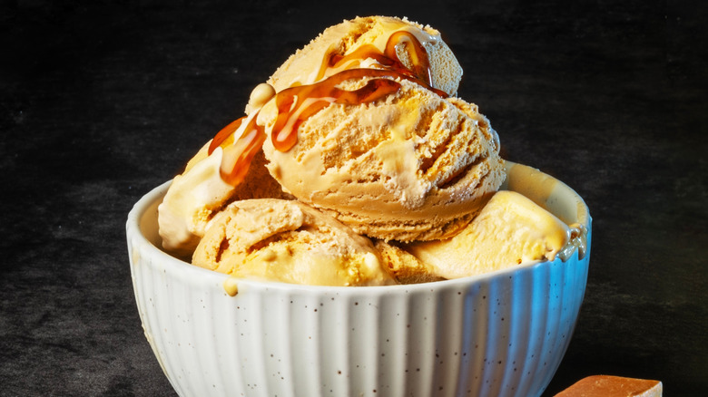 Bowl of butterscotch ice cream against dark backdrop