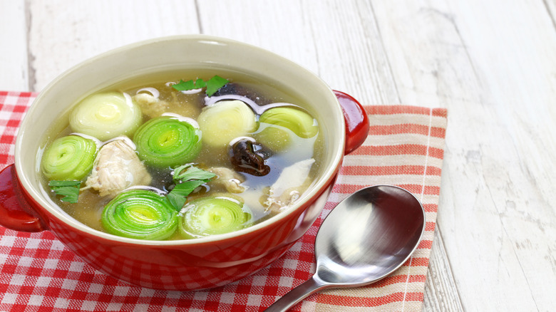 bowl of cock-a-leekie soup on checkered napkin, white table