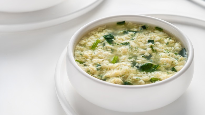 white bowl of stracciatella soup on white table