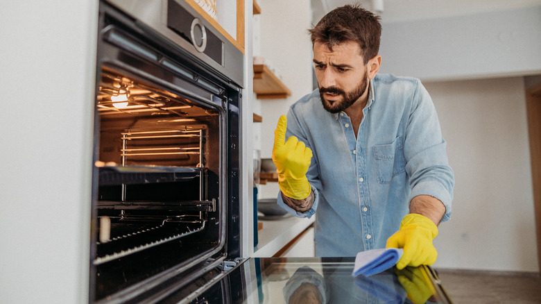 man cleaning oven