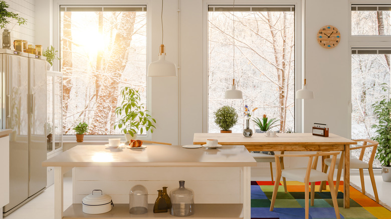 scandinavian kitchen with vintage island and dining table, overlooking snowy forest