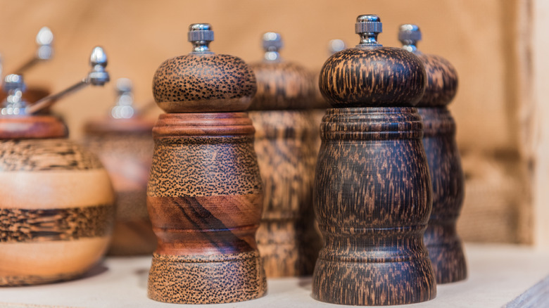 wood peppermills and food mills on a shelf