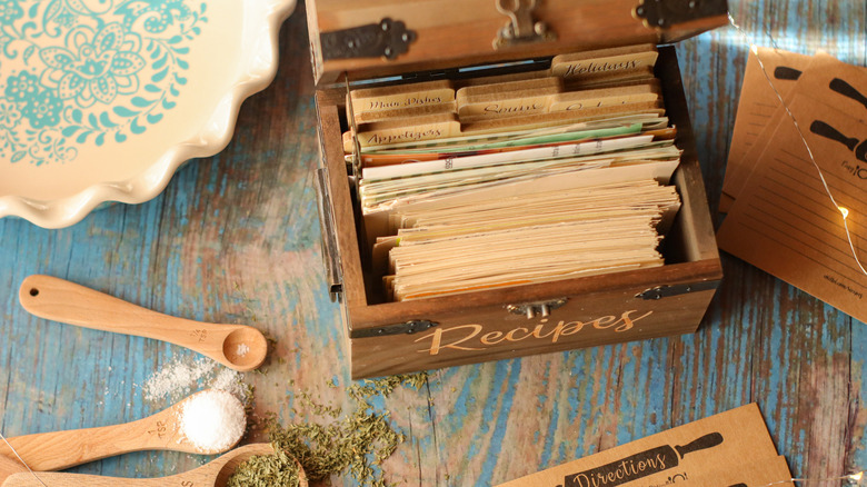 vintage recipe box styled with measuring spoons, shot overhead on wood background