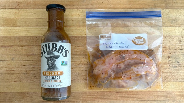 Bottle of Stubb's Citrus & Onion Chicken Marinade and bag with chicken marinating