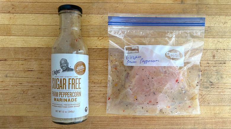 Bottle of G Hughes Sugar Free Parm Peppercorn Marinade and bag with chicken marinating