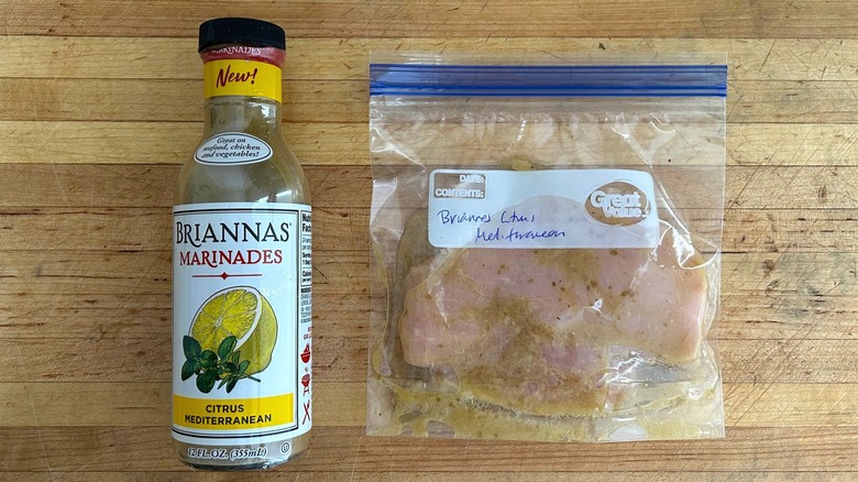 Bottle of Briannas Marinades Citrus Mediterranean and bag with chicken marinating