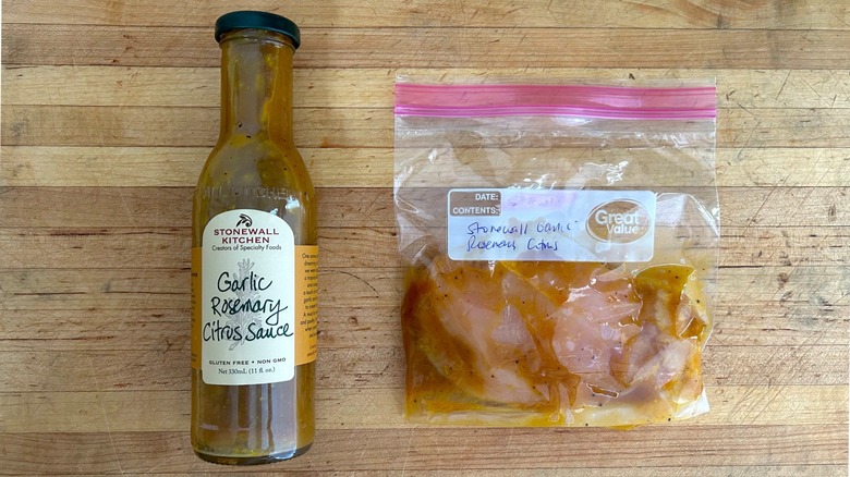 Bottle of Stonewall Kitchen Garlic Rosemary Citrus Sauce and bag with chicken marinating