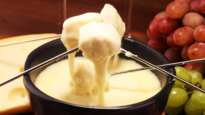 dipping bread pieces in fondue