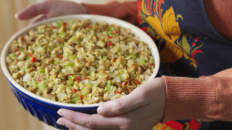 person holding dish of stuffing