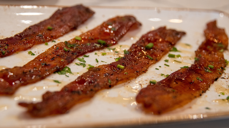 Rows of candied bacon, topped with herbs